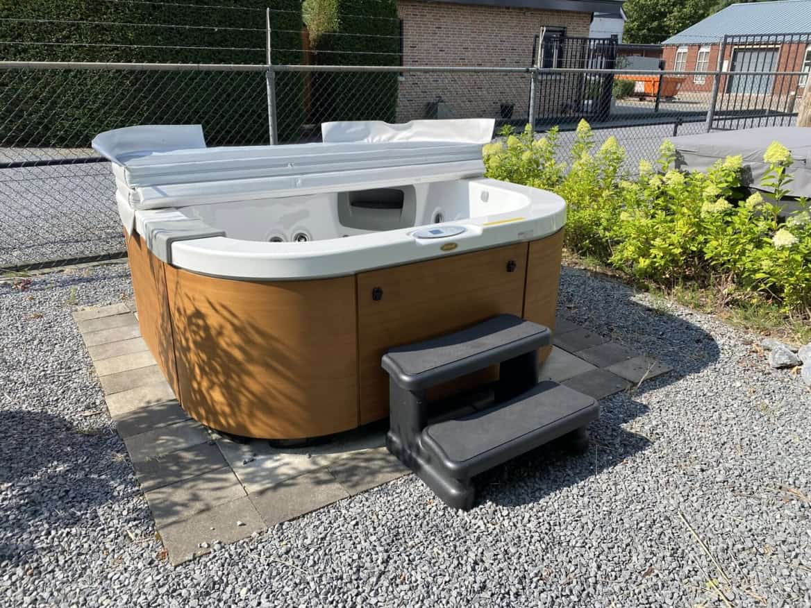 Buitenjacuzzi met afdekking en trapje op grind
