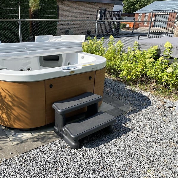 Buitenjacuzzi met afdekking en trapje op grind