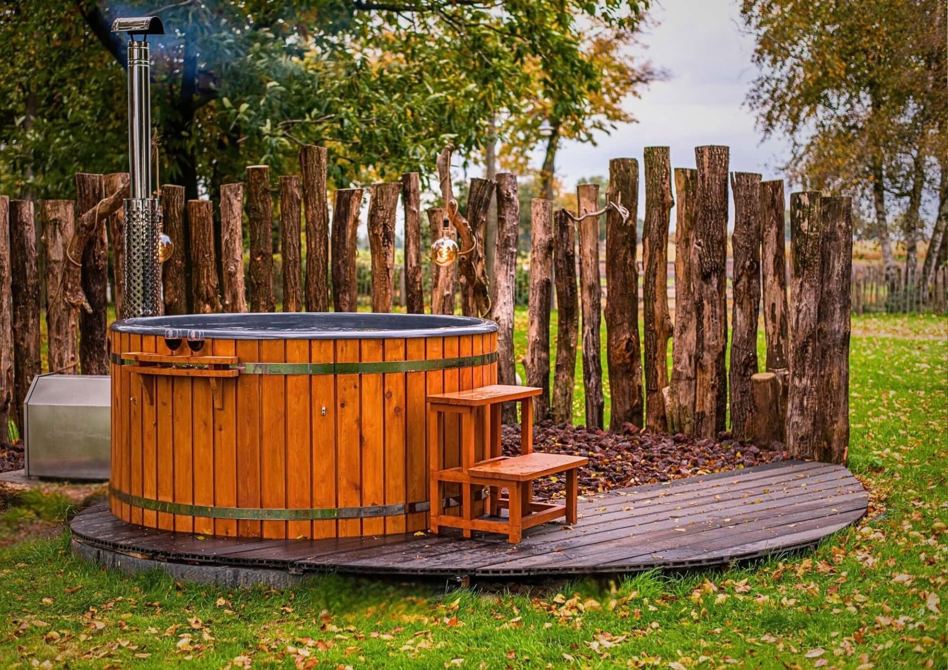 Houten hot tub in een natuurlijke tuinomgeving.
