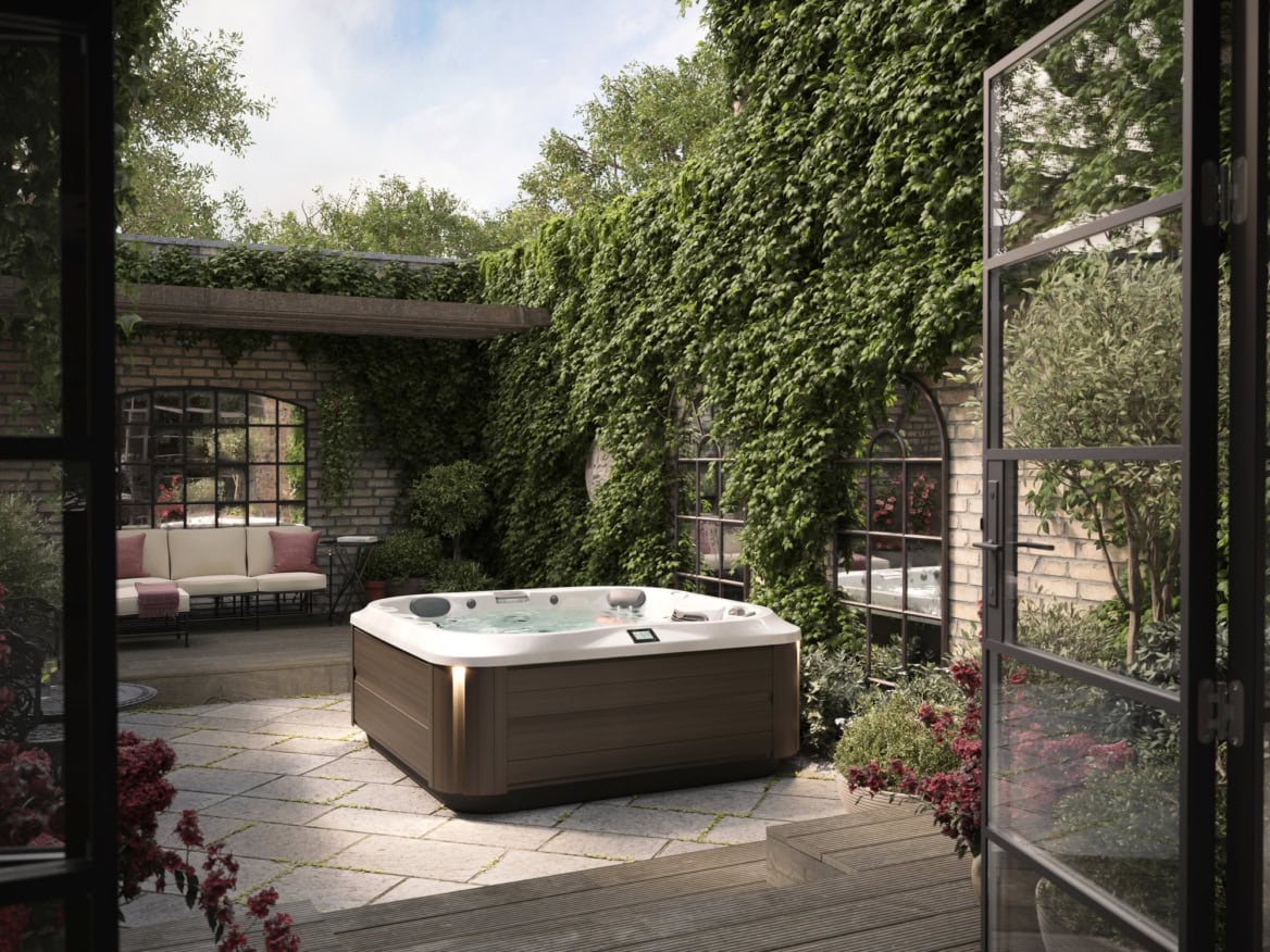 Buitenterras met jacuzzi en groene muren.