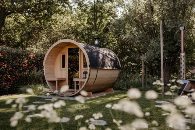 Ronde houten sauna in groene tuin